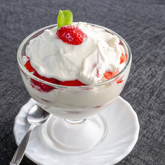 Strawberries with whipped cream in a glass bowl
