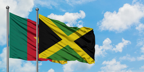 Cameroon and Jamaica flag waving in the wind against white cloudy blue sky together. Diplomacy concept, international relations.
