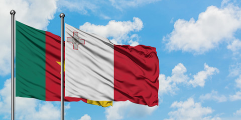 Cameroon and Malta flag waving in the wind against white cloudy blue sky together. Diplomacy concept, international relations.