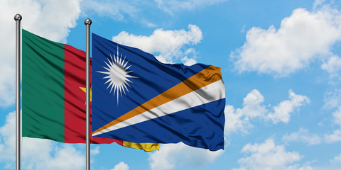 Cameroon and Marshall Islands flag waving in the wind against white cloudy blue sky together....