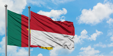 Cameroon and Monaco flag waving in the wind against white cloudy blue sky together. Diplomacy concept, international relations.