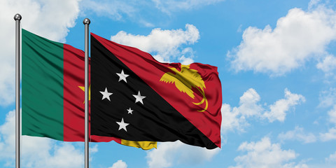 Cameroon and Papua New Guinea flag waving in the wind against white cloudy blue sky together. Diplomacy concept, international relations.