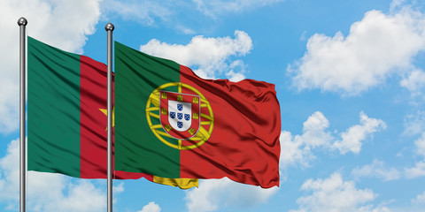 Cameroon and Portugal flag waving in the wind against white cloudy blue sky together. Diplomacy concept, international relations.