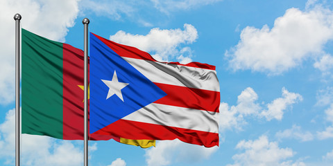 Cameroon and Puerto Rico flag waving in the wind against white cloudy blue sky together. Diplomacy concept, international relations.