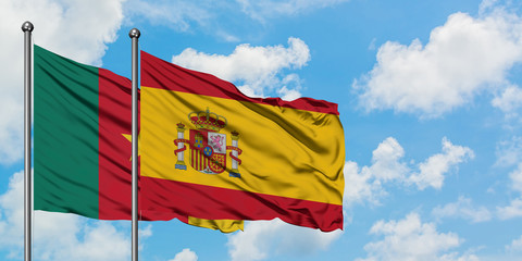 Cameroon and Spain flag waving in the wind against white cloudy blue sky together. Diplomacy concept, international relations.