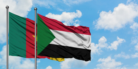 Cameroon and Sudan flag waving in the wind against white cloudy blue sky together. Diplomacy concept, international relations.