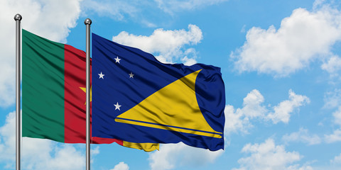 Cameroon and Tokelau flag waving in the wind against white cloudy blue sky together. Diplomacy concept, international relations.
