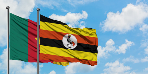 Cameroon and Uganda flag waving in the wind against white cloudy blue sky together. Diplomacy concept, international relations.