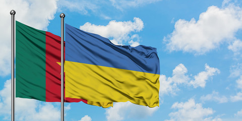 Cameroon and Ukraine flag waving in the wind against white cloudy blue sky together. Diplomacy concept, international relations.