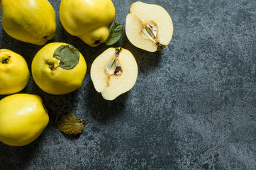 Fresh ripe organic half and whole quinces on rustic background. Healthy yellow fruit quince,...
