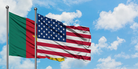 Cameroon and United States flag waving in the wind against white cloudy blue sky together. Diplomacy concept, international relations.