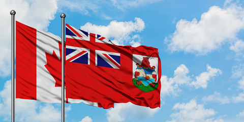 Canada and Bermuda flag waving in the wind against white cloudy blue sky together. Diplomacy concept, international relations.