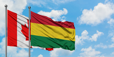 Canada and Bolivia flag waving in the wind against white cloudy blue sky together. Diplomacy concept, international relations.