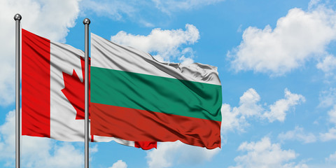 Canada and Bulgaria flag waving in the wind against white cloudy blue sky together. Diplomacy concept, international relations.