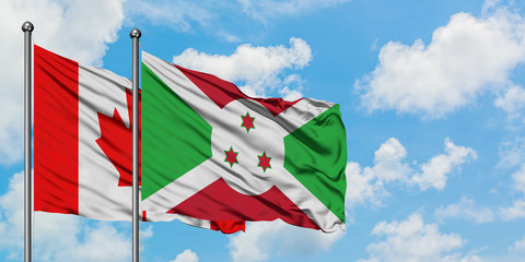 Canada and Burundi flag waving in the wind against white cloudy blue sky together. Diplomacy concept, international relations.