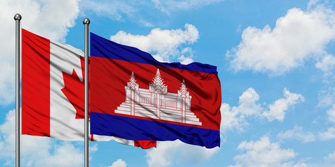 Canada and Cambodia flag waving in the wind against white cloudy blue sky together. Diplomacy concept, international relations.
