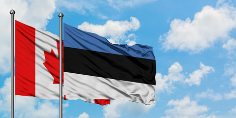 Canada and Estonia flag waving in the wind against white cloudy blue sky together. Diplomacy concept, international relations.