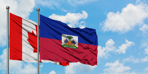 Canada and Haiti flag waving in the wind against white cloudy blue sky together. Diplomacy concept, international relations.