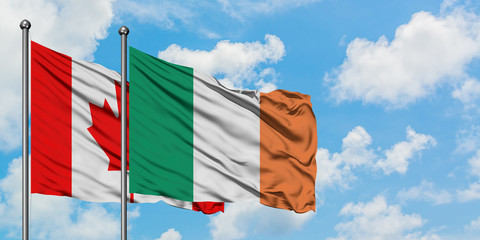 Canada and Ireland flag waving in the wind against white cloudy blue sky together. Diplomacy concept, international relations.
