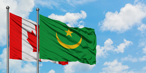 Canada and Mauritania flag waving in the wind against white cloudy blue sky together. Diplomacy concept, international relations.