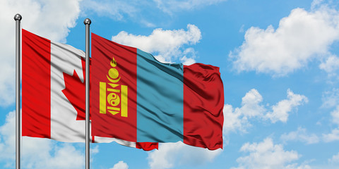 Canada and Mongolia flag waving in the wind against white cloudy blue sky together. Diplomacy concept, international relations.