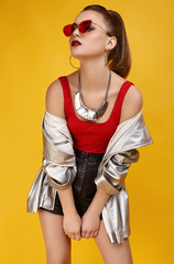 Elegant glamor hipster girl in red top, black shorts and jeans jacket