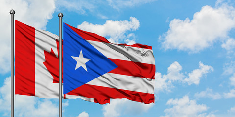 Canada and Puerto Rico flag waving in the wind against white cloudy blue sky together. Diplomacy concept, international relations.