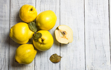 Fresh ripe organic half and whole quinces on rustic background. Healthy yellow fruit quince, Cydonia oblonga