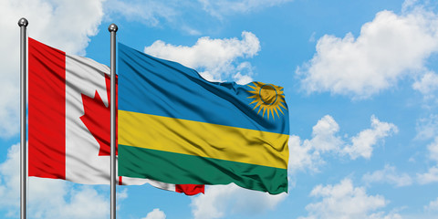 Canada and Rwanda flag waving in the wind against white cloudy blue sky together. Diplomacy concept, international relations.