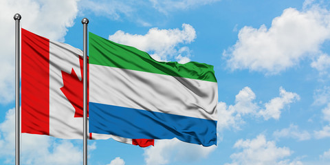 Canada and Sierra Leone flag waving in the wind against white cloudy blue sky together. Diplomacy concept, international relations.