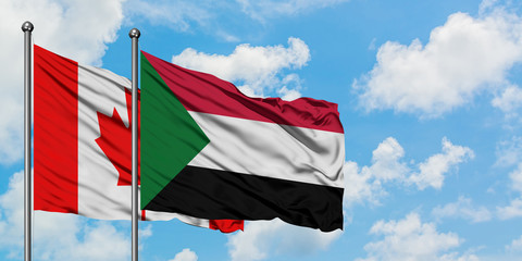 Canada and Sudan flag waving in the wind against white cloudy blue sky together. Diplomacy concept, international relations.