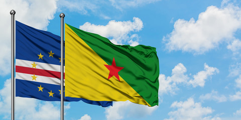 Cape Verde and French Guiana flag waving in the wind against white cloudy blue sky together. Diplomacy concept, international relations.