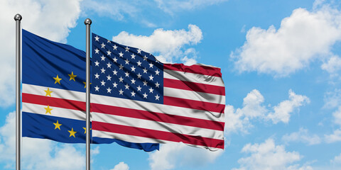 Cape Verde and United States flag waving in the wind against white cloudy blue sky together. Diplomacy concept, international relations.