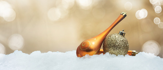 golden christmas spheres on snow in unfocused background