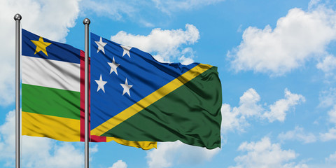 Central African Republic and Solomon Islands flag waving in the wind against white cloudy blue sky together. Diplomacy concept, international relations.