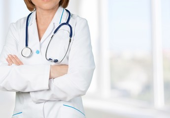 Male doctor with stethoscope on blurred hospital background