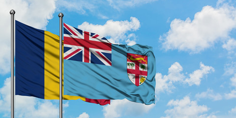 Chad and Fiji flag waving in the wind against white cloudy blue sky together. Diplomacy concept, international relations.