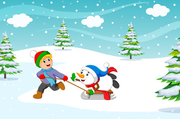 A boy and warm coat playing a sleigh ride with a snow