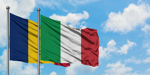 Chad and Italy flag waving in the wind against white cloudy blue sky together. Diplomacy concept,...