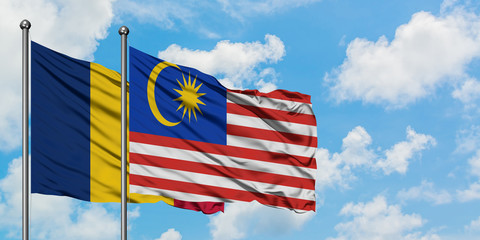 Chad and Malaysia flag waving in the wind against white cloudy blue sky together. Diplomacy concept, international relations.