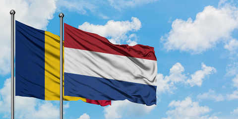Chad and Netherlands flag waving in the wind against white cloudy blue sky together. Diplomacy...