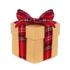 Brown wrapped Christmas gift box with red plaid bow and ribbon. Side view isolated on a white background.