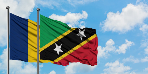 Chad and Saint Kitts And Nevis flag waving in the wind against white cloudy blue sky together....