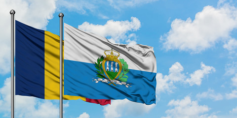 Chad and San Marino flag waving in the wind against white cloudy blue sky together. Diplomacy...