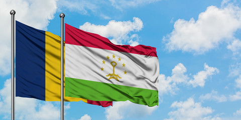 Chad and Tajikistan flag waving in the wind against white cloudy blue sky together. Diplomacy...