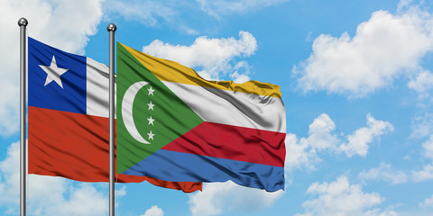 Chile and Comoros flag waving in the wind against white cloudy blue sky together. Diplomacy concept, international relations.