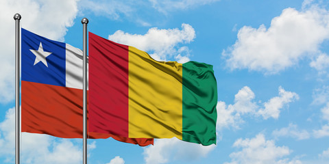 Chile and Guinea flag waving in the wind against white cloudy blue sky together. Diplomacy concept, international relations.