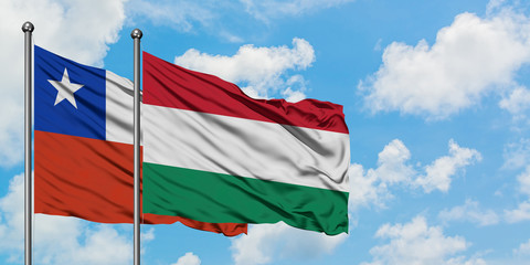Chile and Hungary flag waving in the wind against white cloudy blue sky together. Diplomacy concept, international relations.