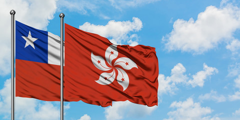 Chile and Hong Kong flag waving in the wind against white cloudy blue sky together. Diplomacy concept, international relations.