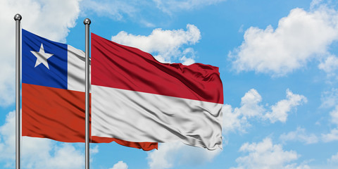 Chile and Indonesia flag waving in the wind against white cloudy blue sky together. Diplomacy concept, international relations.